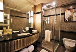 马尼拉Diamond Hotel Philippines的一间带水槽和淋浴的浴室