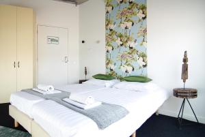 阿姆斯特丹Stunning apartments close to Amstel river的一间卧室配有两张白色的床和花卉壁纸
