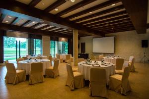 慕斯Kirimaya Golf Resort Spa - SHA Plus Certified的一间会议室,配有桌椅和屏幕