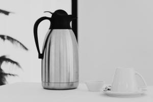 EleftheroúpolisPravi Hotel的茶壶和茶杯的黑白相片