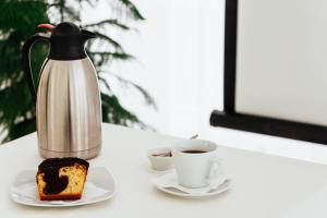 EleftheroúpolisPravi Hotel的茶壶,一块蛋糕和一杯咖啡