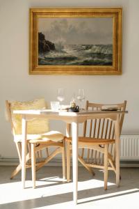阿灵厄Grønbechs Hotel的一张带两把椅子的白色餐桌和一幅画