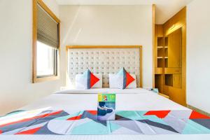 博帕尔FabHotel Naman Palace的一间卧室配有一张大床和彩色床罩