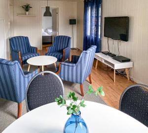 莫舍恩Mosjøen Romutleie - Sentrum的一间带椅子和桌子的房间以及一台电视