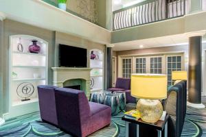 莫里斯维尔罗利达勒姆国际机场酒店奎因塔套房酒店的客厅配有紫色椅子和壁炉