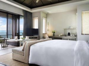 奈通海滩Pullman Phuket Arcadia Naithon Beach的卧室配有一张白色的大床和一张沙发。