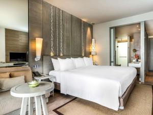 奈通海滩Pullman Phuket Arcadia Naithon Beach的一间带白色大床的卧室和一间客厅