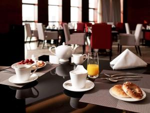 无锡无锡新湖铂尔曼大酒店的餐桌,盘子和一杯橙汁