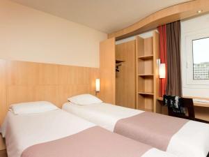 伊西莱穆利诺依西雷莫里诺塞纳河谷宜必思酒店的酒店客房设有两张床和窗户。