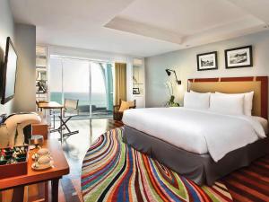 库塔库塔海滩遗产酒店 - 由雅高酒店集团管理的酒店客房设有一张大床和一间客厅。