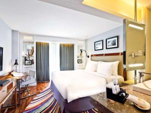 库塔库塔海滩遗产酒店 - 由雅高酒店集团管理的酒店客房设有一张大床和一张书桌。