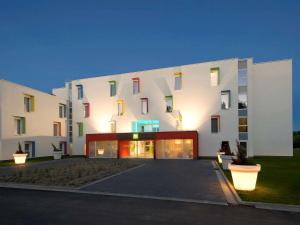 尼韦勒尼韦尔宜必思尚品酒店的一座白色的大建筑,设有色彩缤纷的窗户
