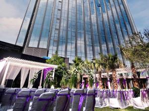 贵阳贵阳铂尔曼大酒店的建筑前的一组紫色椅子