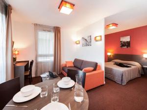 普瓦捷普特瑞斯爱达格公寓式酒店的酒店客房设有餐桌和床。