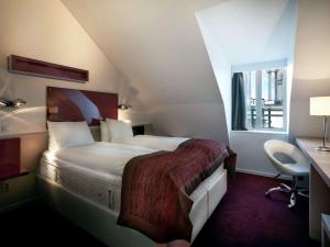 斯德哥尔摩斯德哥尔摩奥登普兰宜必思尚品酒店的酒店客房设有一张大床和一张书桌。