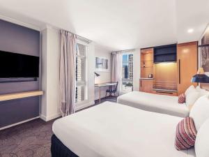 布里斯班布里斯班乔治国王广场美居酒店的酒店客房设有两张床和一台平面电视。