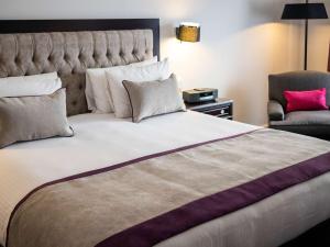 布宜诺斯艾利斯布宜诺斯艾利斯雷科莱塔索菲提酒店的一间卧室配有一张大床和一把椅子