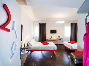 巴勒莫Ibis Styles Palermo President的酒店客房 - 带两张带红色枕头的床