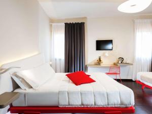 巴勒莫Ibis Styles Palermo President的酒店客房配有一张带红色枕头的白色床。
