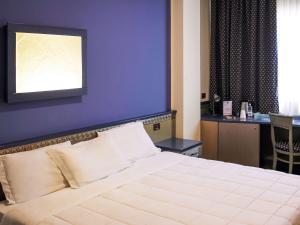 巴勒莫Ibis Styles Palermo President的一间卧室配有一张大床和紫色墙壁