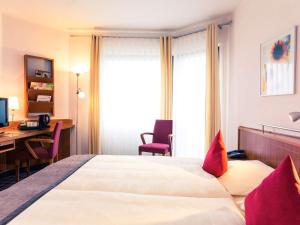 多特蒙德Mercure Hotel Dortmund Messe的酒店客房配有一张床、一张书桌和一台电脑