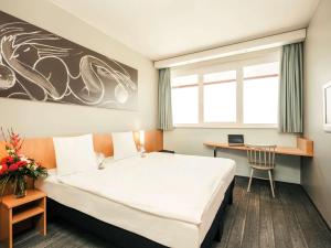 施韦夏特维也纳机场宜必思酒店的酒店客房设有一张大床和一张书桌。