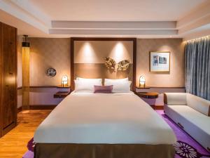 新加坡Sofitel Singapore Sentosa Resort & Spa的卧室配有一张白色的大床和一张沙发。