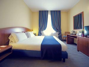 热那亚热那亚圣比亚焦美居酒店的酒店客房带一张大床,带蓝色窗帘