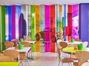 巴拉奈里奥-坎布里乌Ibis Styles Balneário Camboriú - 1 Quadra do Mar的餐厅设有桌椅和色彩缤纷的墙壁