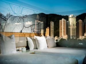 香港香港柏宁铂尔曼酒店的一张带白色枕头和城市壁画的床