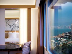 香港香港柏宁铂尔曼酒店的客房设有带床的窗户,享有美景。