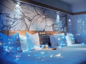 香港香港柏宁铂尔曼酒店的一间卧室配有一张蓝色灯床