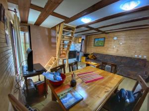 ZaovineVikendica NEVEN的一间带木桌的客厅和一间带沙发的房间