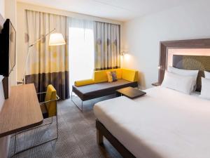 霍夫多普诺富特阿姆斯特丹史基浦机场酒店的酒店客房,配有床和沙发