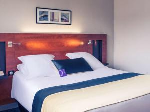 莫勒帕莫里帕斯圣康坦美居酒店的一张白色的大床,上面有蓝色的枕头