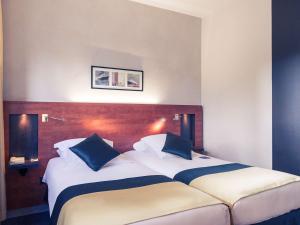 莫勒帕莫里帕斯圣康坦美居酒店的一间卧室配有两张带蓝白色枕头的床