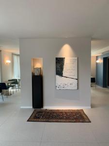 格拉迪斯卡迪松佐HT Hotel Trieste的一间有地毯和照片的白色墙壁的房间