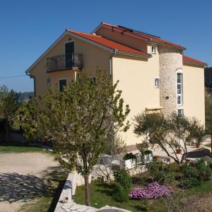 苏佩塔斯卡德拉加Apartments Batistić的前面有一棵树的房子
