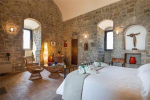 蒙泰卡蒂尼瓦尔迪切奇纳Torre dei Belforti的卧室配有一张石墙内的大床