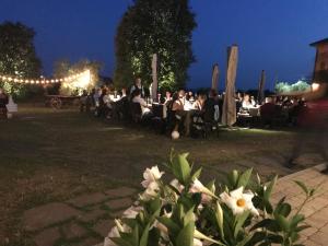 Ragogna罗萨爱科利卡萨农庄旅馆的一群人晚上坐在公园的桌子上