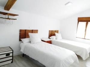 埃尔莫拉尔Casa Rural Teresa的白色墙壁客房的两张床