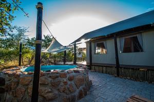 侯斯普瑞特Mountain View Safari Lodge的一座房子,设有游泳池,毗邻石墙
