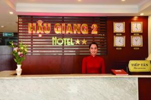 芹苴Hau Giang 2 Hotel Cần Thơ的坐在柜台后面的女人