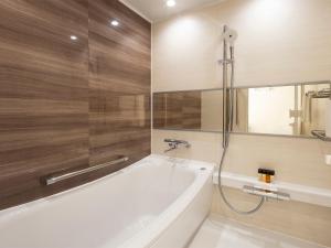 札幌札幌格兰大酒店的带浴缸和镜子的浴室