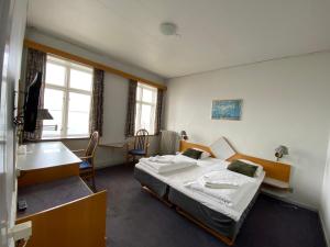 LøgstørLøgstør Badehotel - Hotel du Nord的一间卧室配有一张床、一张桌子和一张桌子