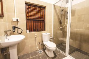 贾夫纳Thambu Illam的浴室配有卫生间、盥洗盆和淋浴。