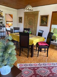 布达厄尔什Helga Vendégház的用餐室配有黄色的桌子和椅子