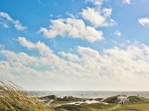 森讷维5 person holiday home in Ringk bing的一片拥有岩石、蓝天和云的海滩