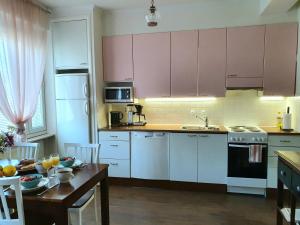 波里Tina's Place的厨房配有粉红色的橱柜和一张桌子