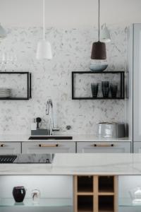 纳坦利Luxury Apartment Hovi的厨房配有白色橱柜和水槽